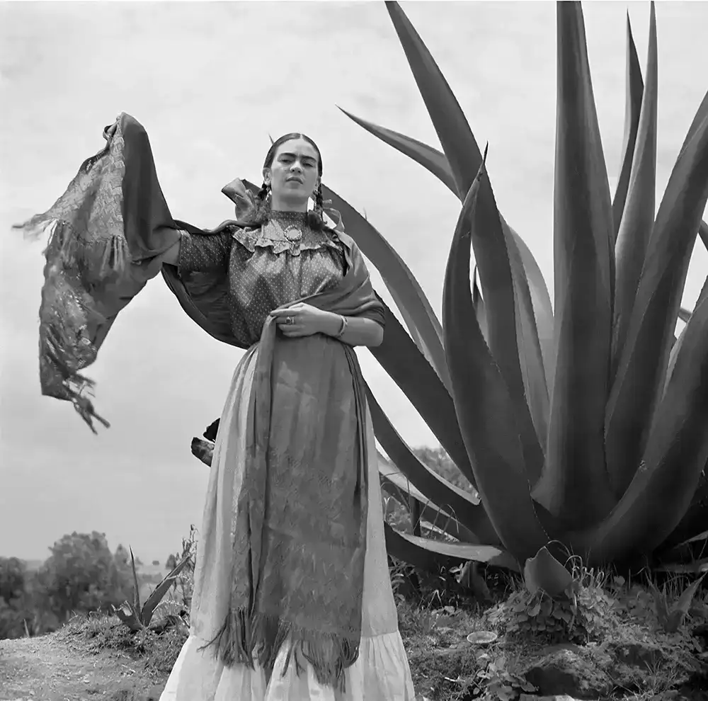 Image of Frida Kahlo standing next to an agave plant