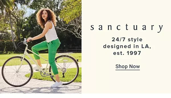 An image of a woman wearing a white sleeveless top, green pants and sneakers riding a bike. The Sanctuary logo. 24 7 style designed in LA, est. 1997. Shop now.