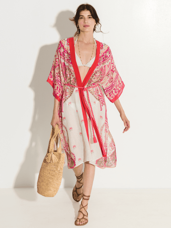 woman wearing coral and cream colored paisley print duster