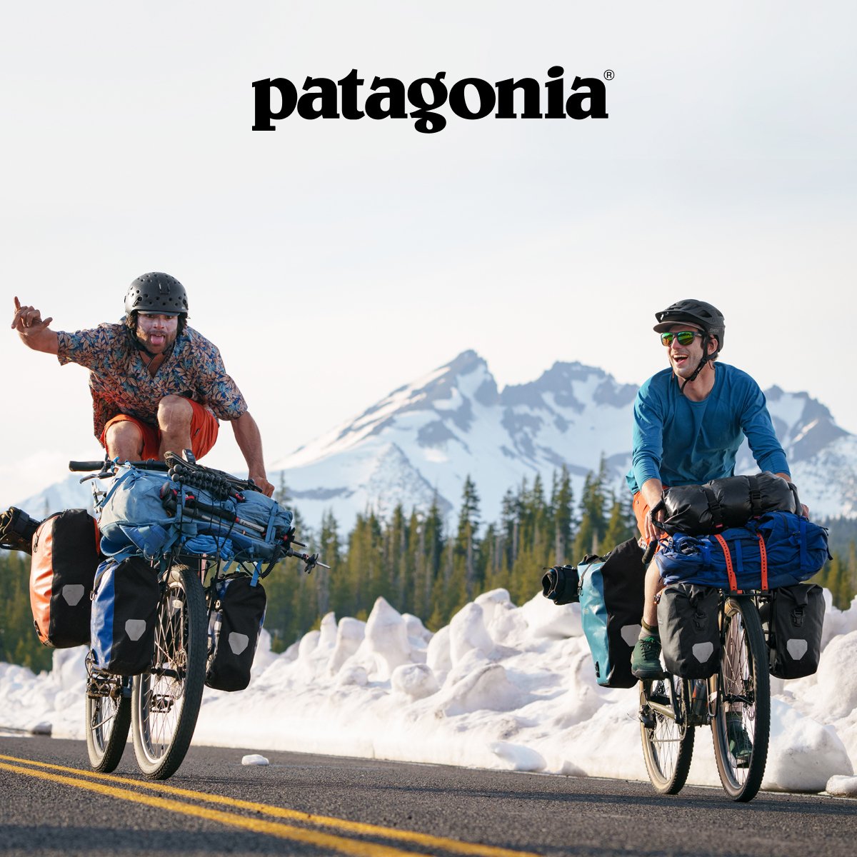 Two people riding bikes through the snow mountains.