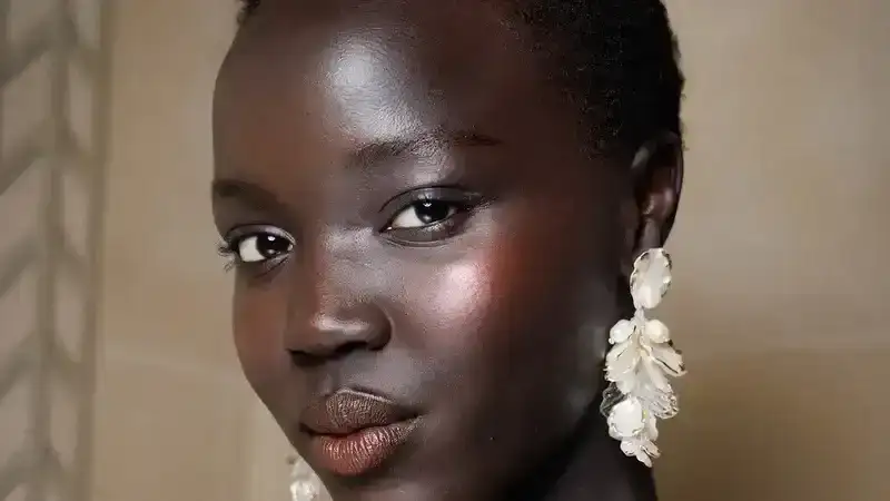 A model in a black floral dress backstage at Oscar de la Renta's runway show. 