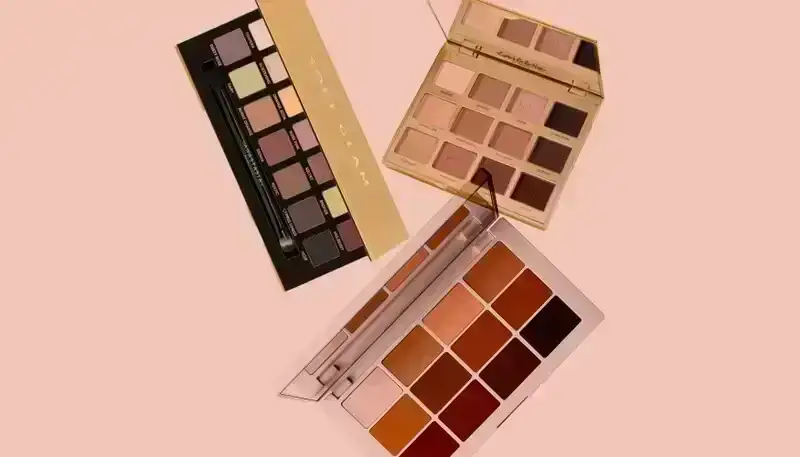 Best Eyeshadow Palettes: Three eye shadow palettes from Anastasia BEverly Hills, Tarte, and Makeup by Mario on a light pink background.