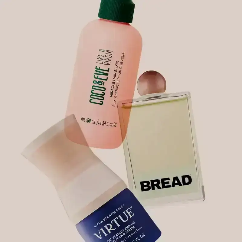 Best Split End Treatments: Bottles of hair-care product from Coco & Eve, Bread Beauty Supply, and Virtue on a beige background