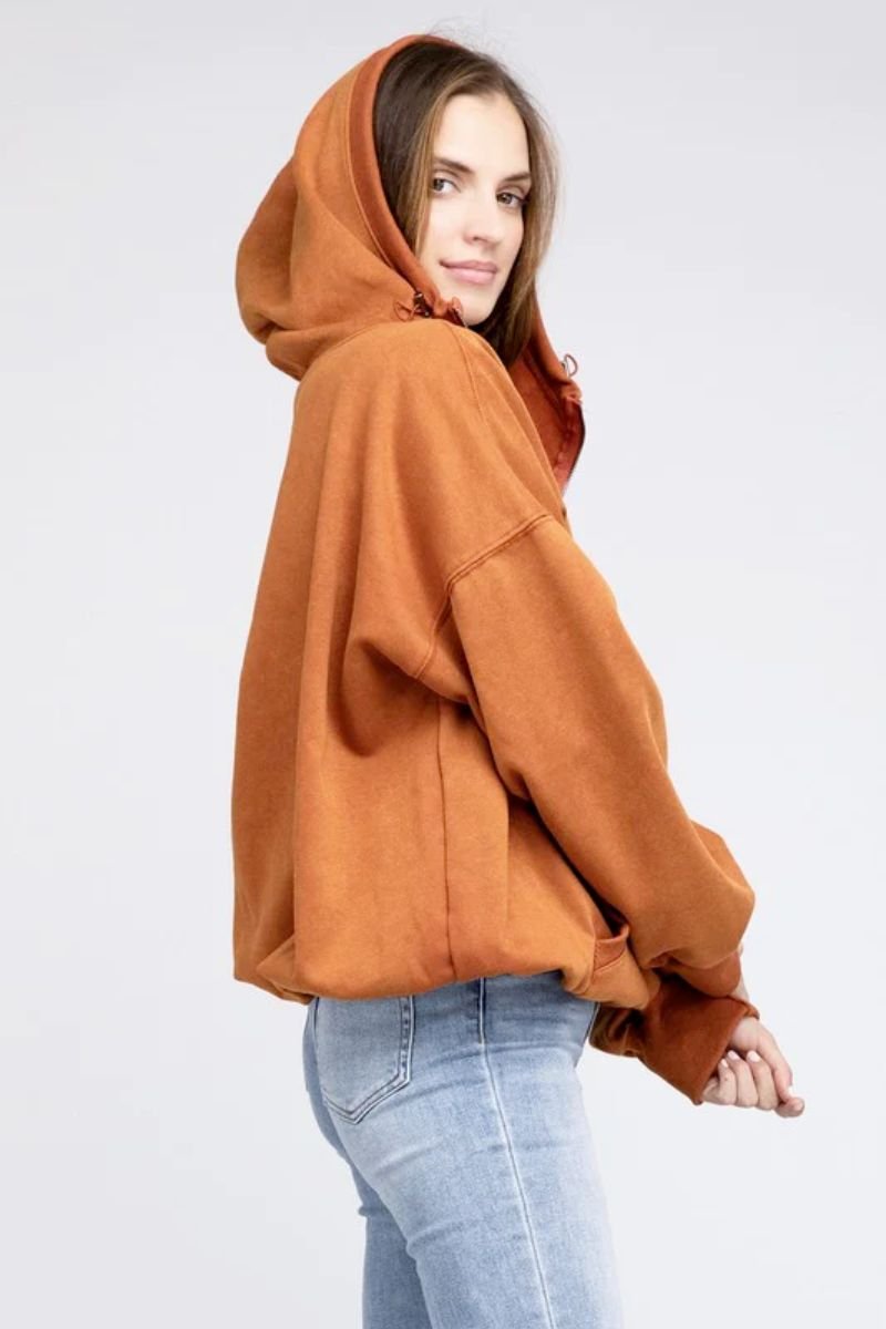 Stitch Detailed Elastic Hem Hoodie. The model is wearing a rust colored hoodie with a half zip and blue jeans.