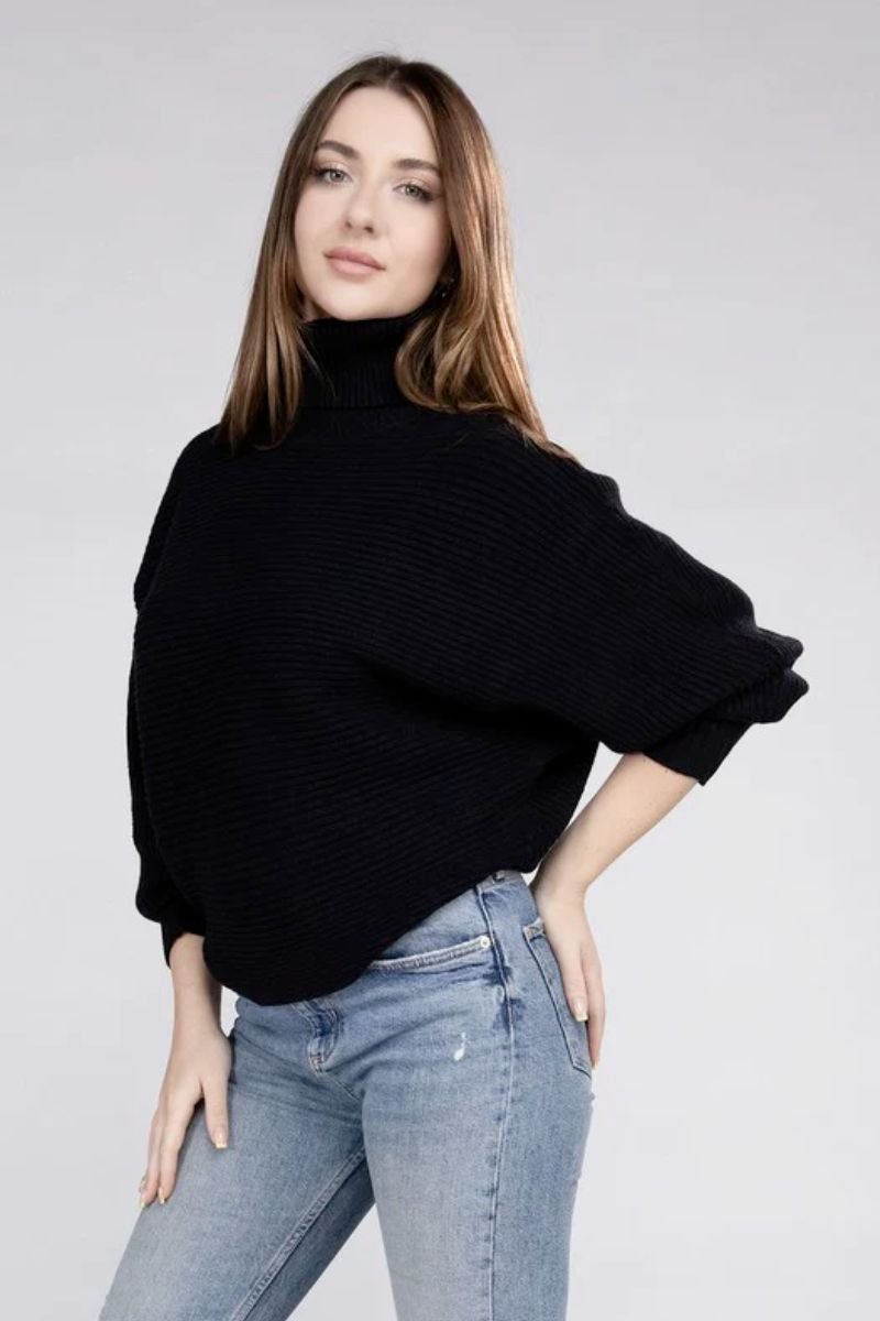 Viscose Dolman Sleeve Turtleneck Sweater. The model is wearing a black sweater with blue jeans.