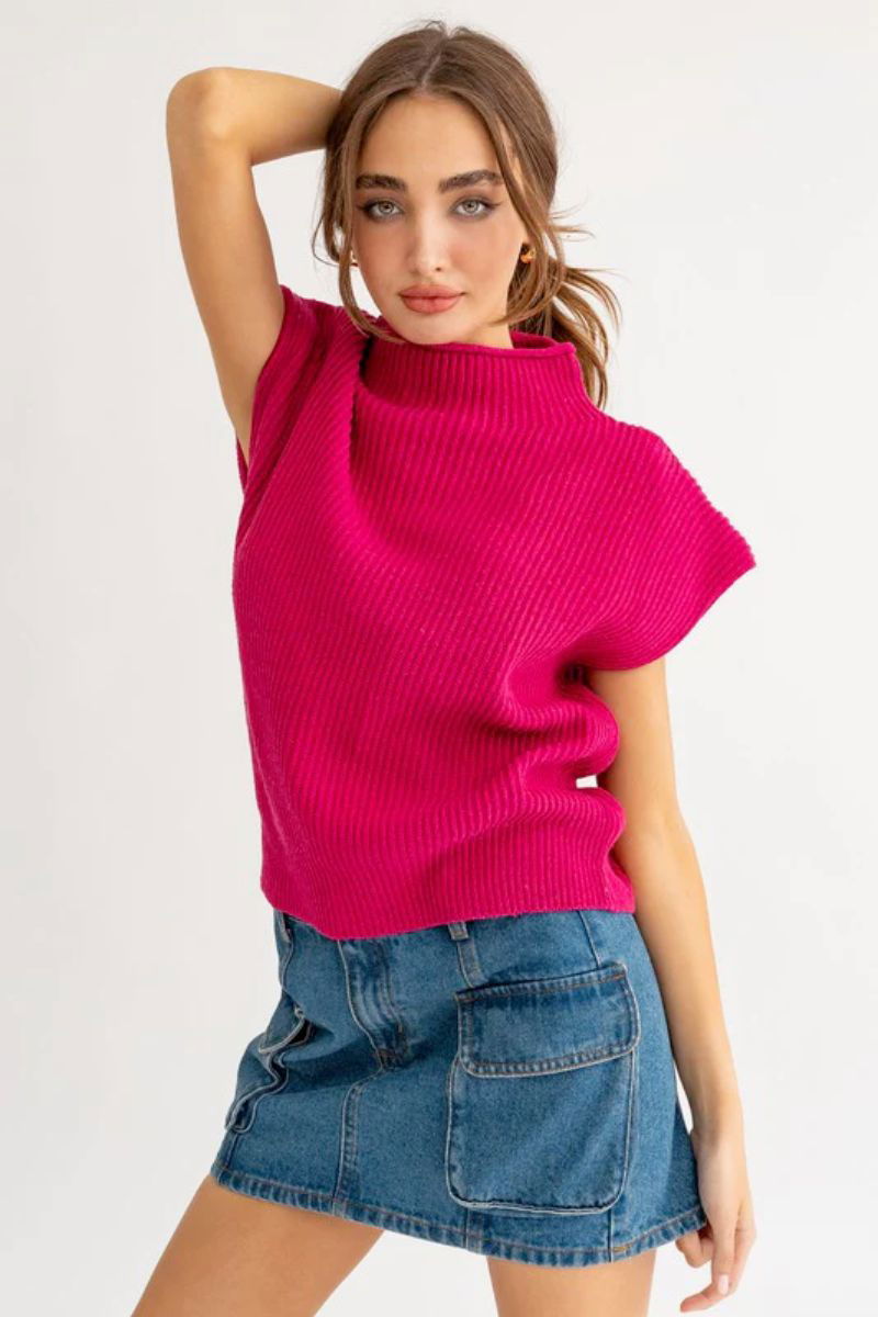 The model is wearing a fuchsia sweater with short sleeves, along with a jean skirt.