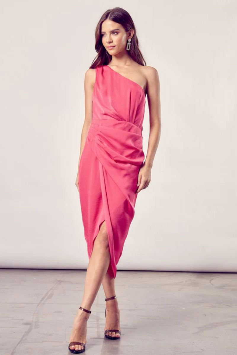 One Shoulder Wrap Dress. The model is wearing a paradise pink dress and silver earrings.