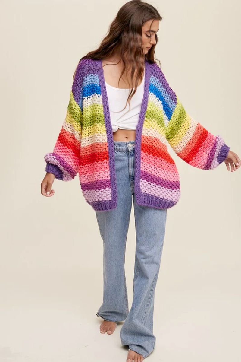 Hand Crochet Multi Color Oversized Open Cardigan. The model is wearing a white tank top and a rainbow cardigan with blue jeans.