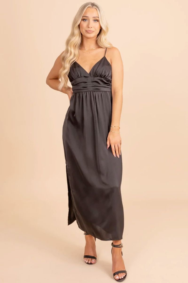 Timeless Treasure Sleeveless Maxi Dress. The model is wearing a black dress with spaghetti straps and a pleated waistband. She is also wearing black heels.