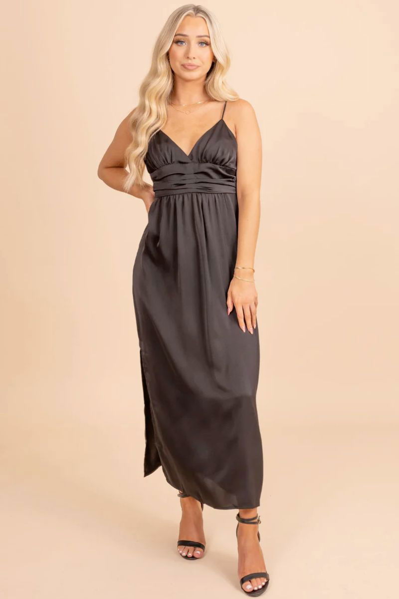 Timeless Treasure Sleeveless Maxi Dress. The model is wearing a black dress with spaghetti straps and a pleated waistband. She is also wearing black heels.