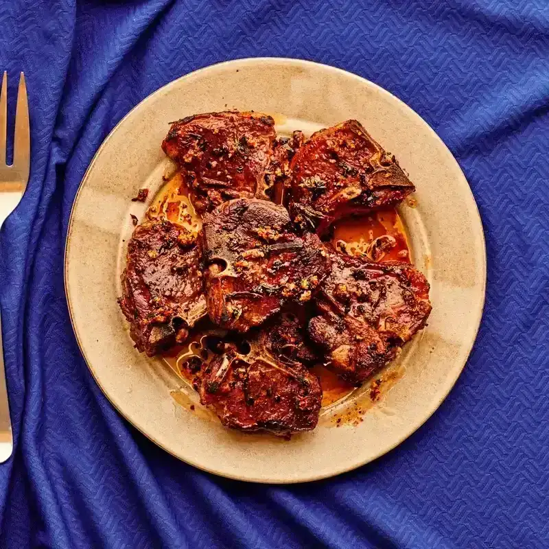 Lamb Chops on a golden plate placed on a blue background