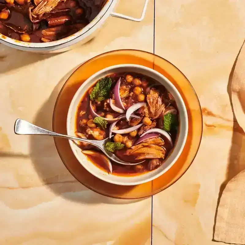 Spiced Pork and Chickpea Stew on a brown marbled surface