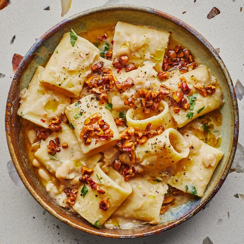 A pantry pasta recipe featuring rigatoni and walnuts in a vegan cream sauce.