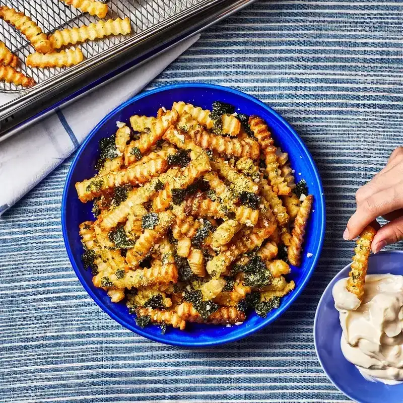 Garlic-Nori Fries in a blue bowl on a pinstriped fabric