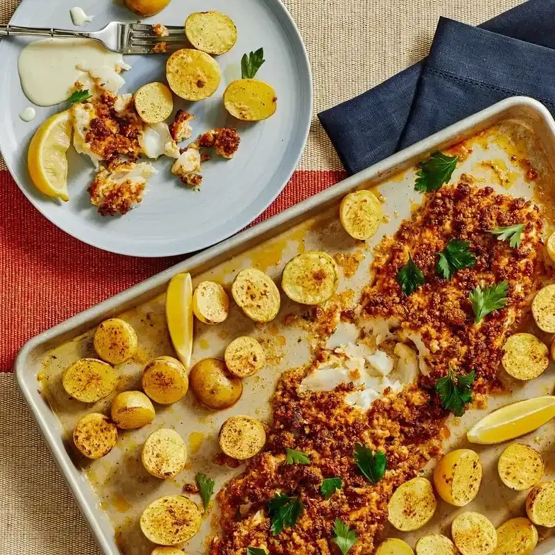 Roast Cod with Chorizo Crisp on a sheet tray with a single serving of both on a light blue plate