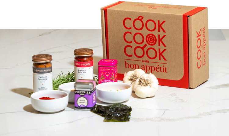 Variety of fresh and shelf-stable ingredients next to a Cook with Bon Appétit box.