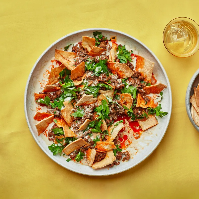 Plate of Creamy Tahini and Harissa Beef with crunchy pita chips 