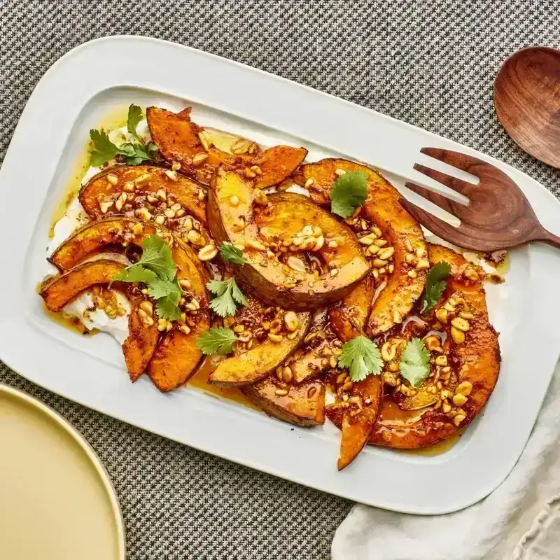 Sheet-Pan Berbere Roasted Kabocha with Brown Butter Peanuts and Lime on a white platter