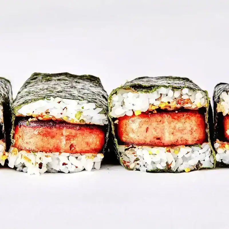 Four pieces of Spam musubi: Fried spam layered with white rice and wrapped in nori.