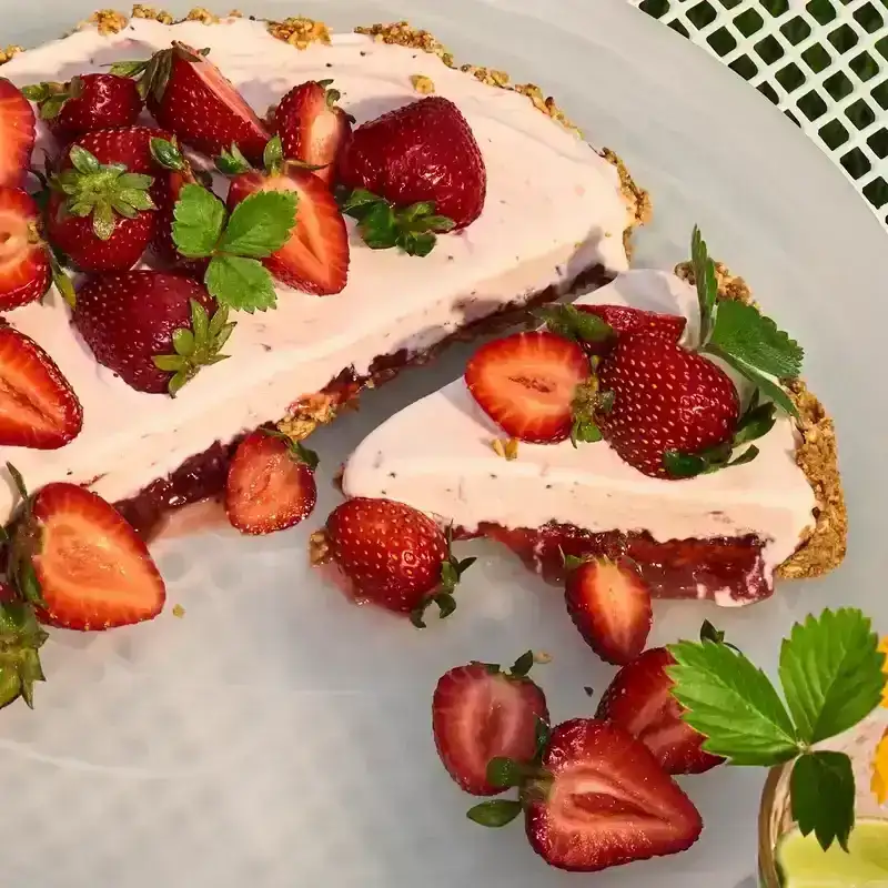 Strawberry ice cream pretzel pie on a white picnic table.