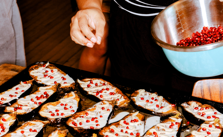 A chef prepping a eggplant dish for the oven.