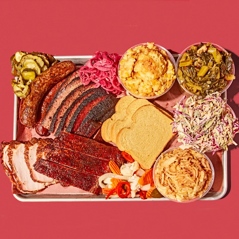 An assortment of BBQ food on a metal trey