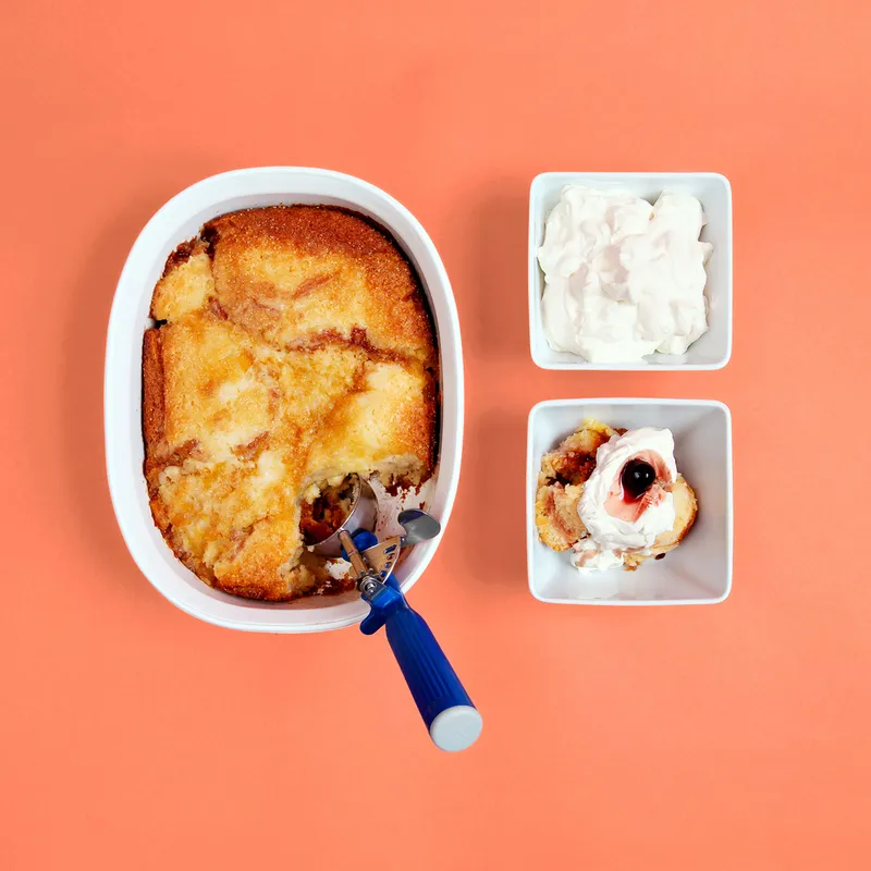 A pineapple cobbler served with whipped cream and luxardo cherries.