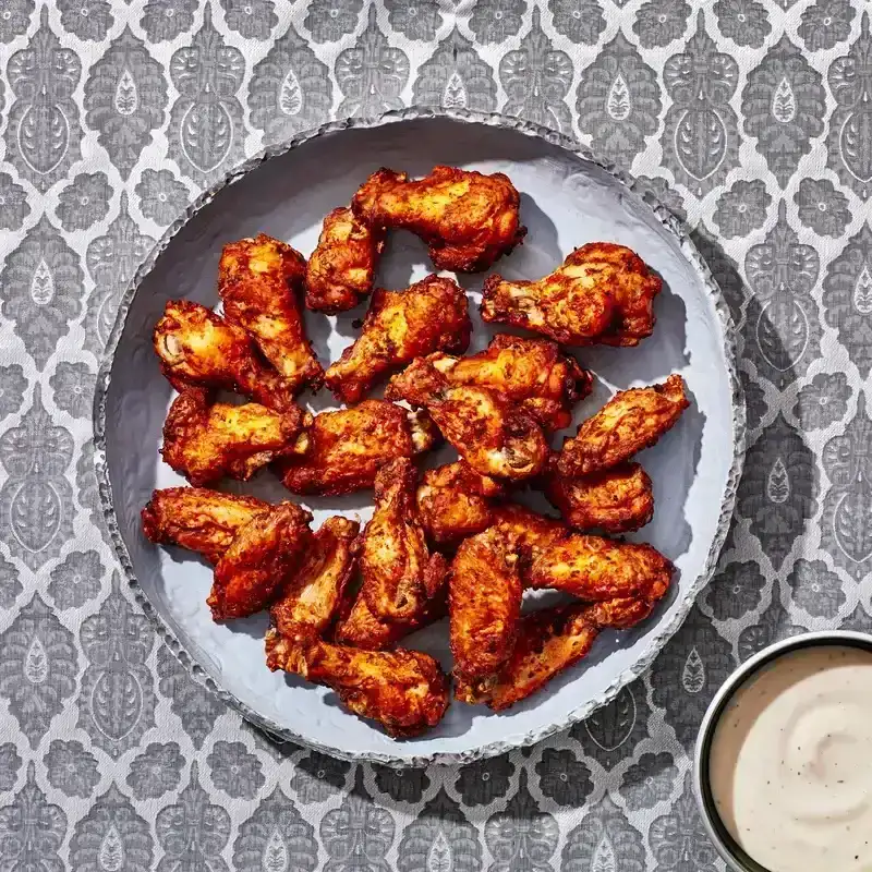 Bowl of crispy Air Fryer Chicken Wings with a side of ranch dressing.