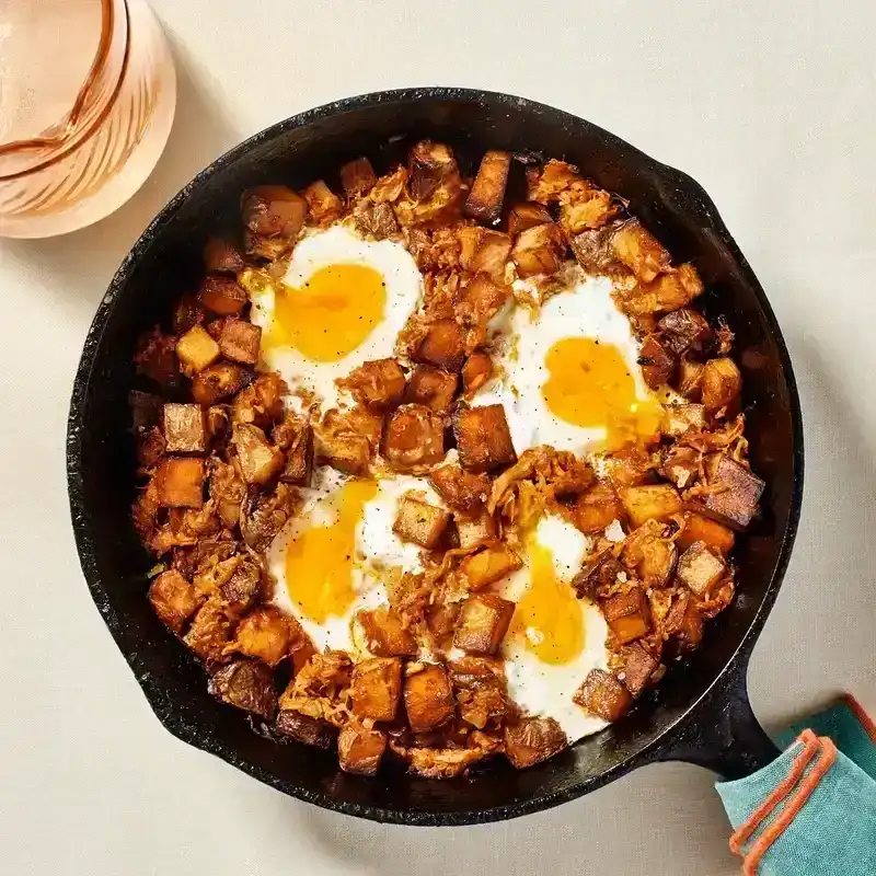 Sauerkraut and Potato Skillet in a black cast iron skillet placed on a white surface