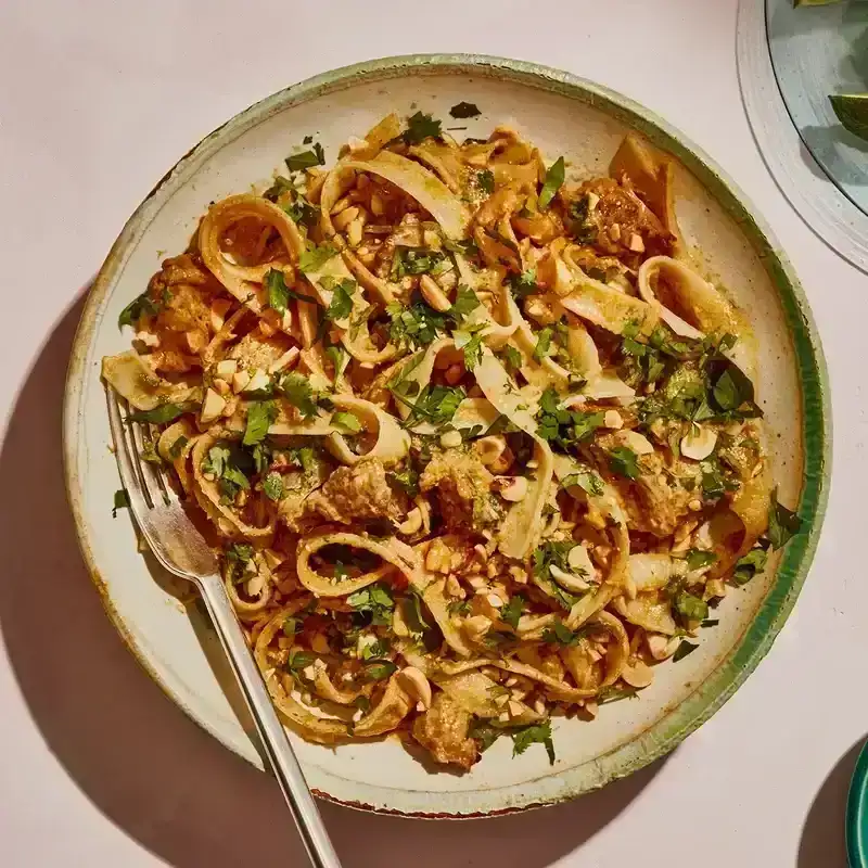 Long noodles mixed with shredded pork and herbs, served with limes and nuts.