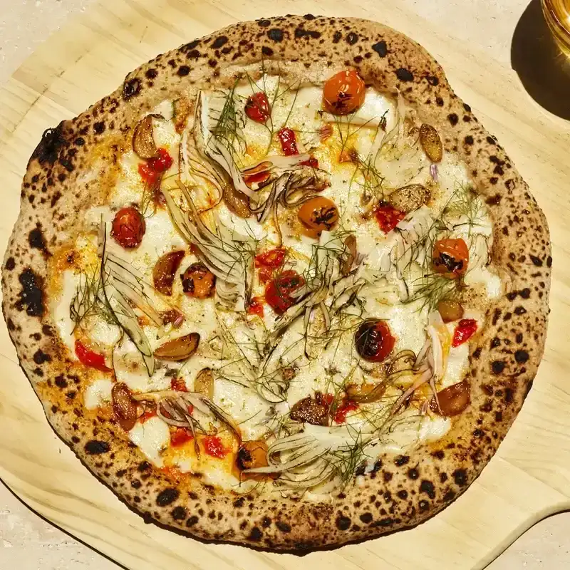 Tomato and Fennel Pizza on wooden pizza peel