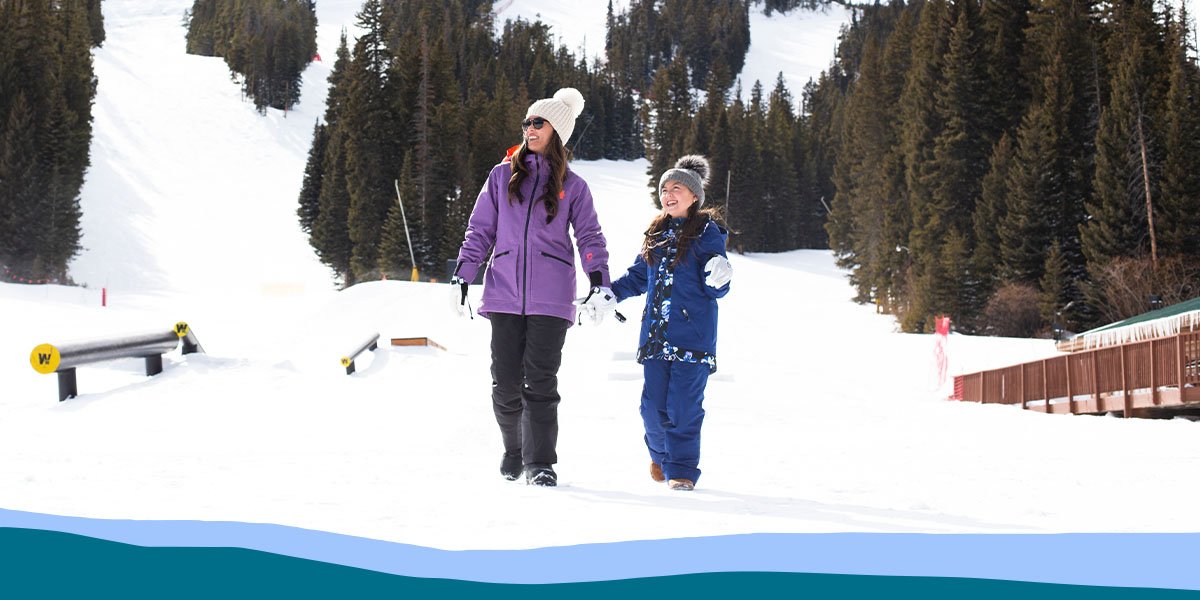 Two people walking hand in hand in snow