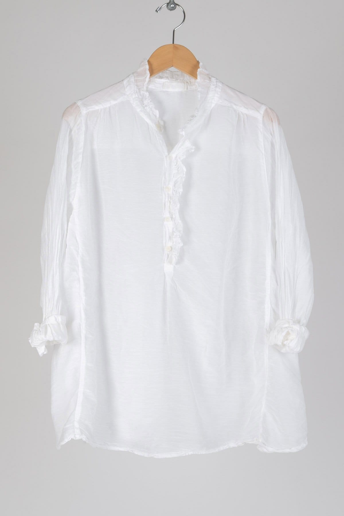 Oversized tunic length button up with a collar. Featuring tab sleeves and a high low hem.