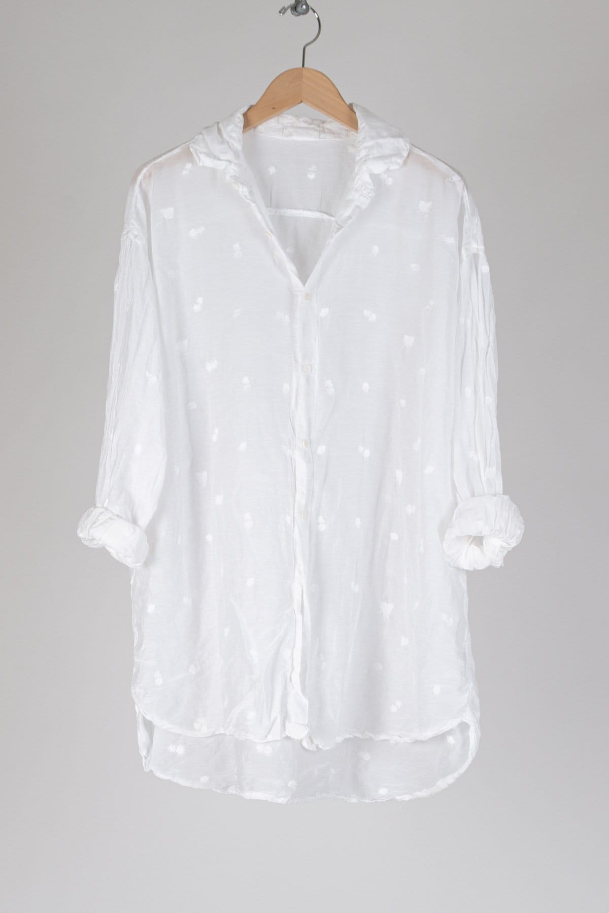 Oversized tunic length button up with a collar. Featuring tab sleeves and a high low hem, in embroidered cottonsilk