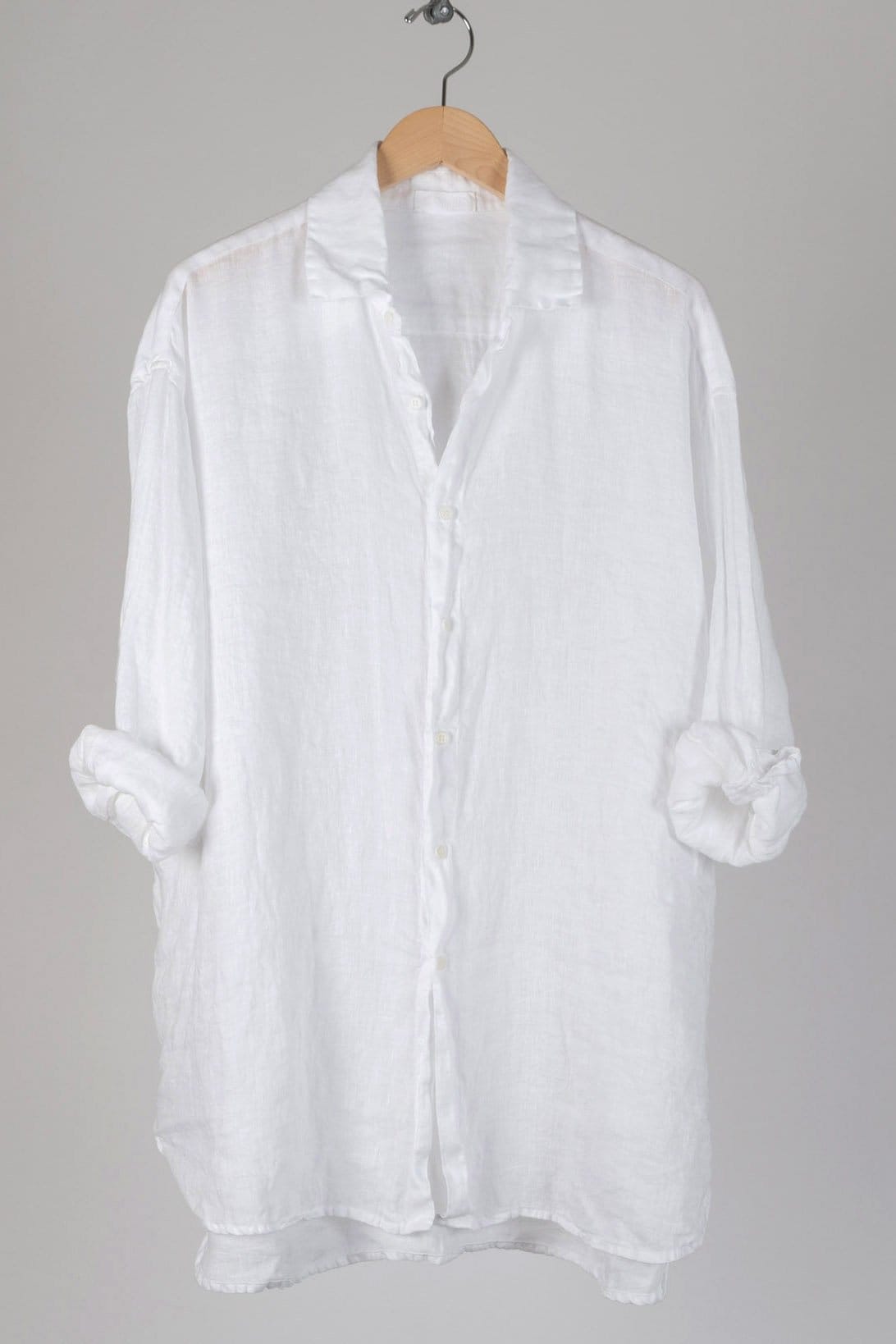 Oversized tunic length button up with a collar. Featuring tab sleeves and a high low hem.