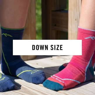 Read Now - two sets of feet on a wooden deck, wearing Darn Tough children's socks