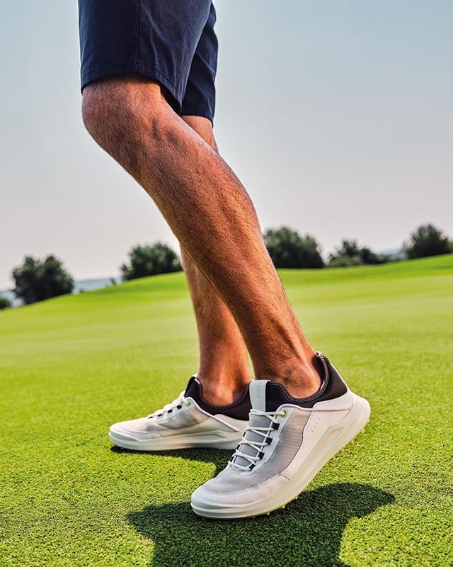 Model wearing golf shoes on course