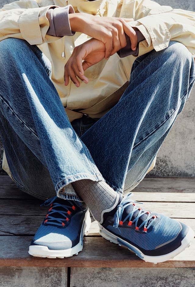 Man sitting outside wearing blue sneakers