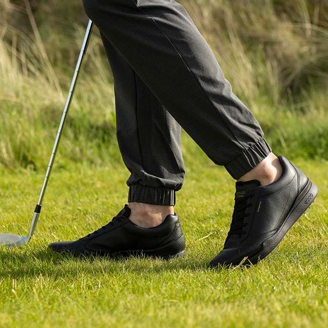 Man wearing black golf shoes