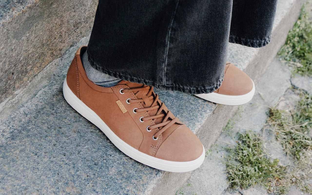 Man sitting on concrete steps wearing brown sneakers