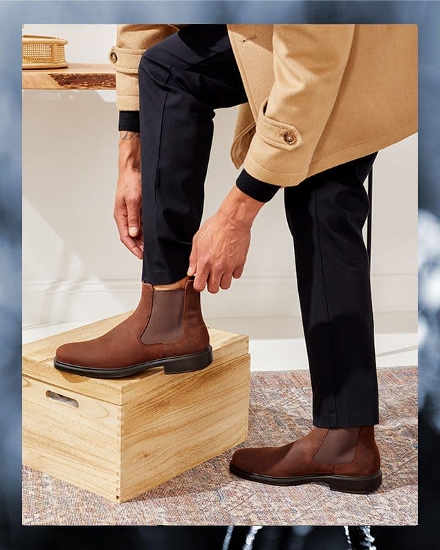 Man putting on brown chelsea boot