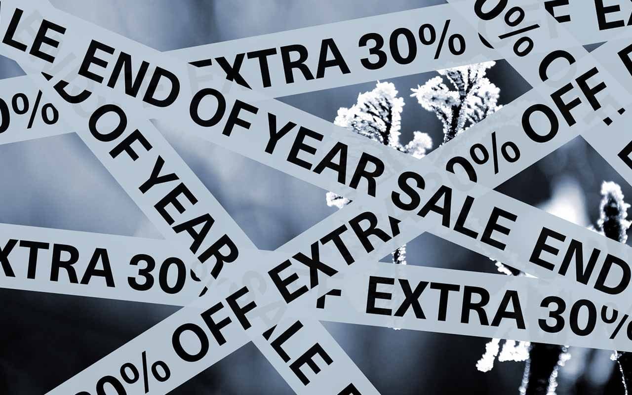 Winter background with ribbons that read "end of year sale" and "extra 30% off"