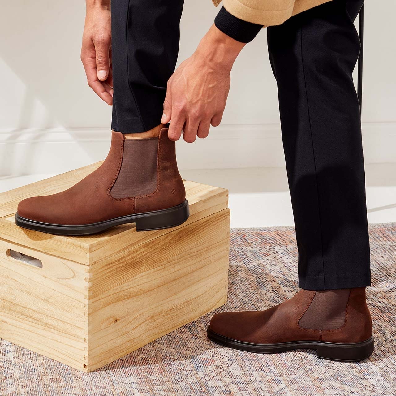 Man putting on brown dress boots