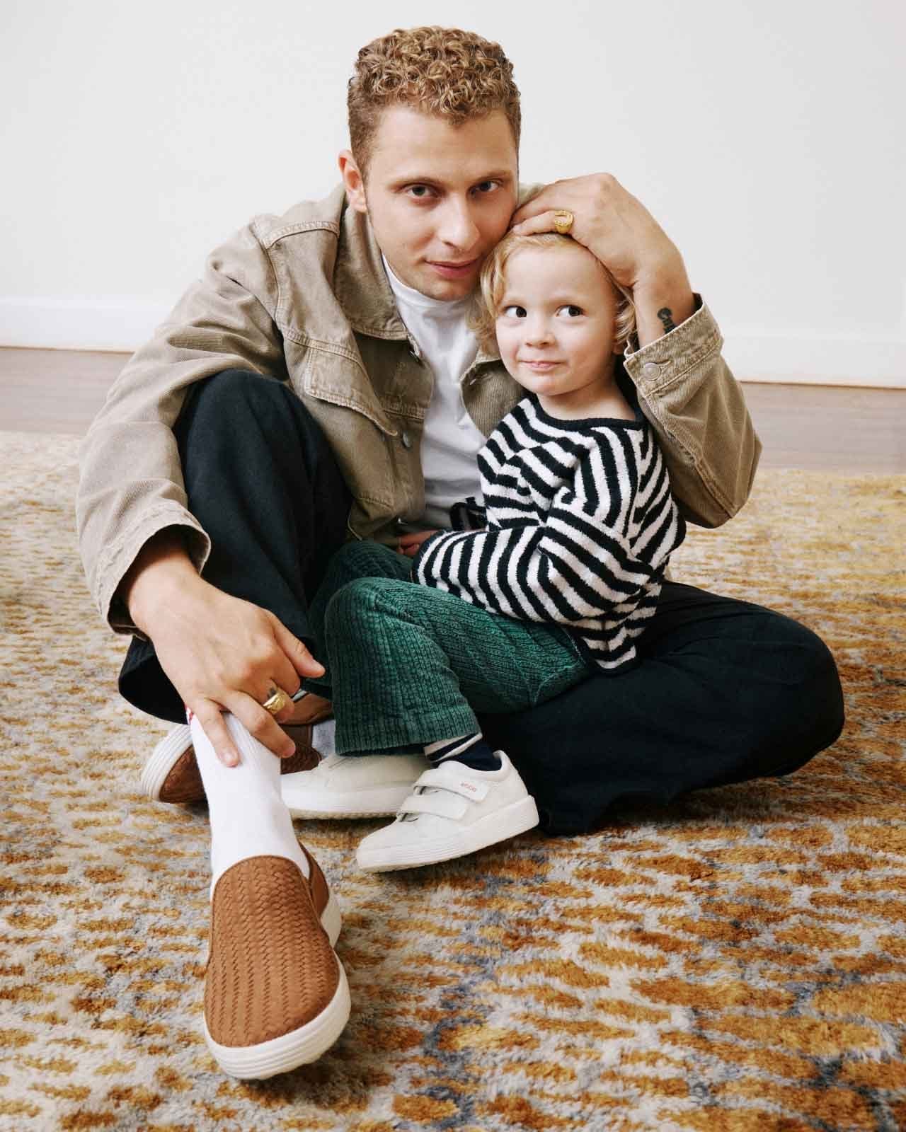 Man sitting on floor holding small child