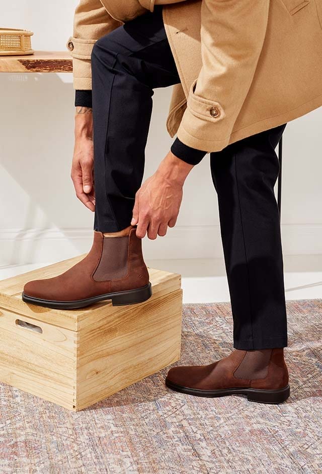 Man putting on Chelsea boots