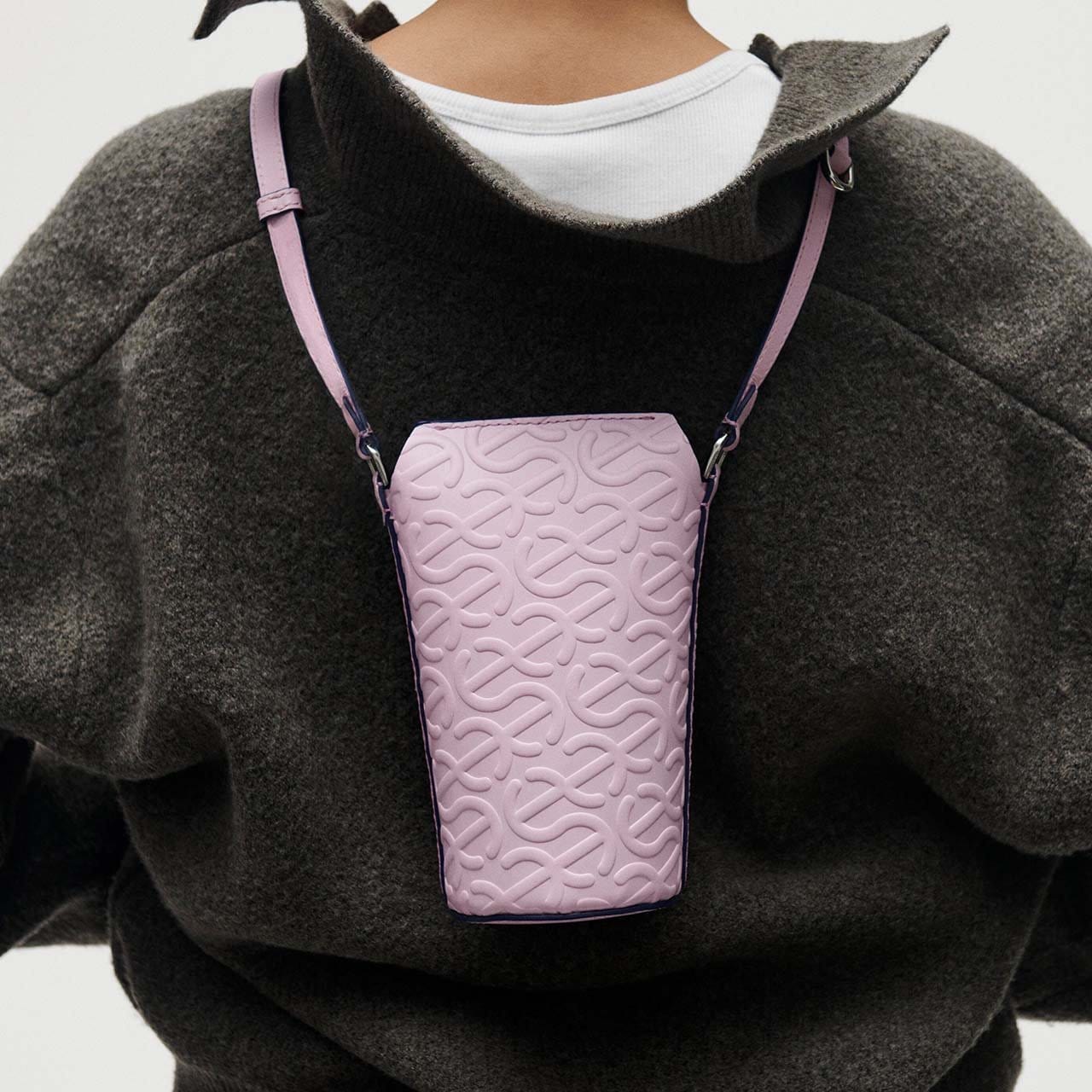 Model wearing pink pot bag around their neck