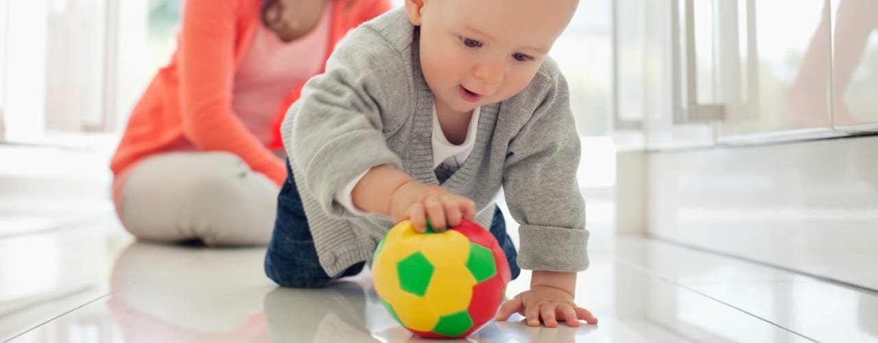 Toddler rolling ball on the floor