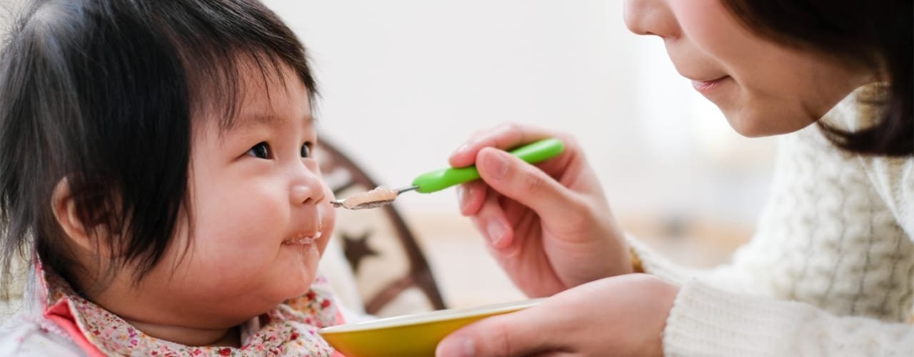 Mom spoon-feeding toddler