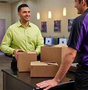 A happy customer picks up his package from FedEx Office.
