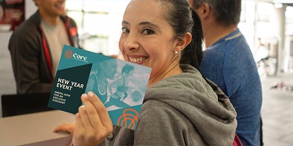 Woman holding up an invitation advertising a 'NEW YEAR EVENT.'